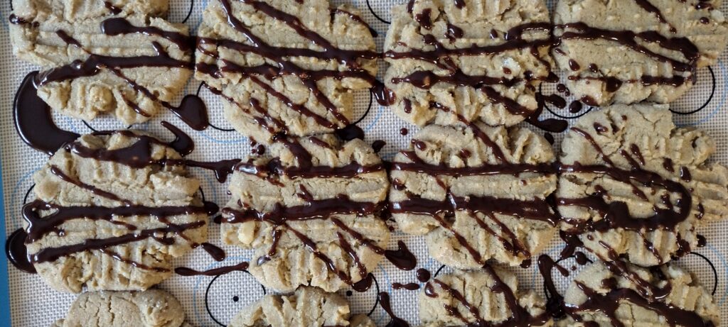 Peanut butter cookies with macadamia nut and chocolate ganache drizzle