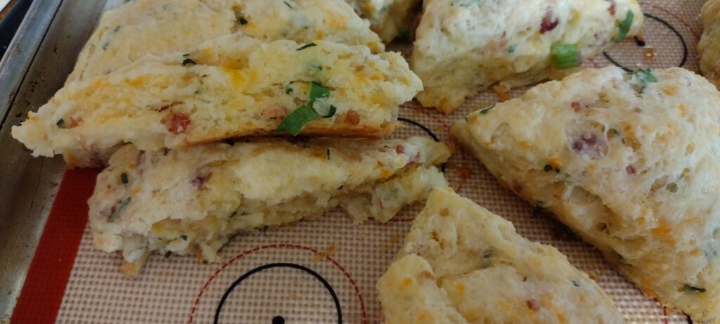 Cheese and bacon scone torn in half to show flakiness.