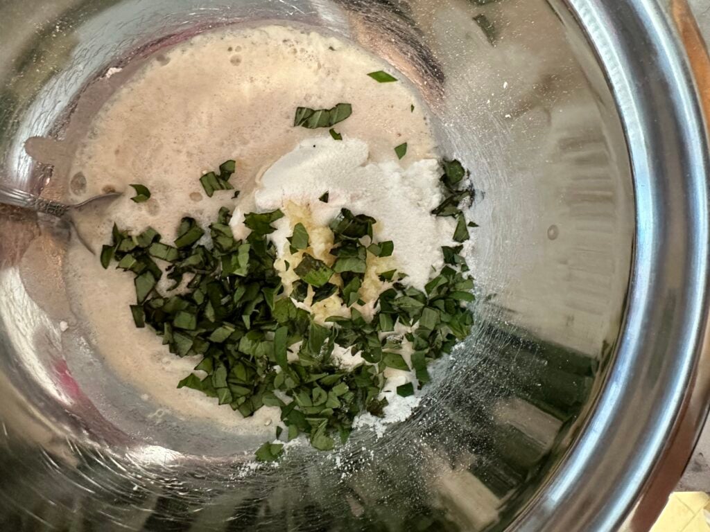 Flour, yeast, herbs, and salt in a mixing bowl