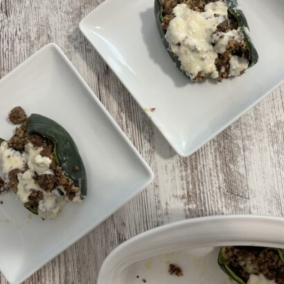 Two plates of stuffed poblano peppers