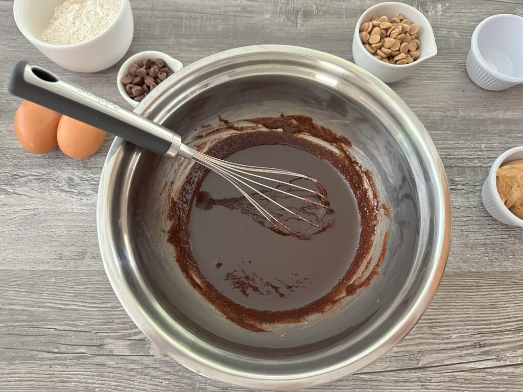 Melted butter and cocoa powder mixed together in a mixing bowl.