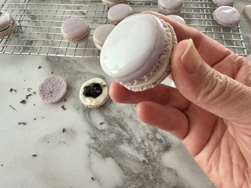 Demonstrating how the macaron is coated with the icing.