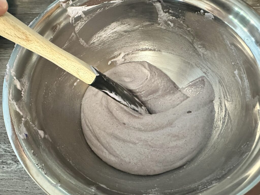 Dragging the spatula through the batter to create a cohesive batter.