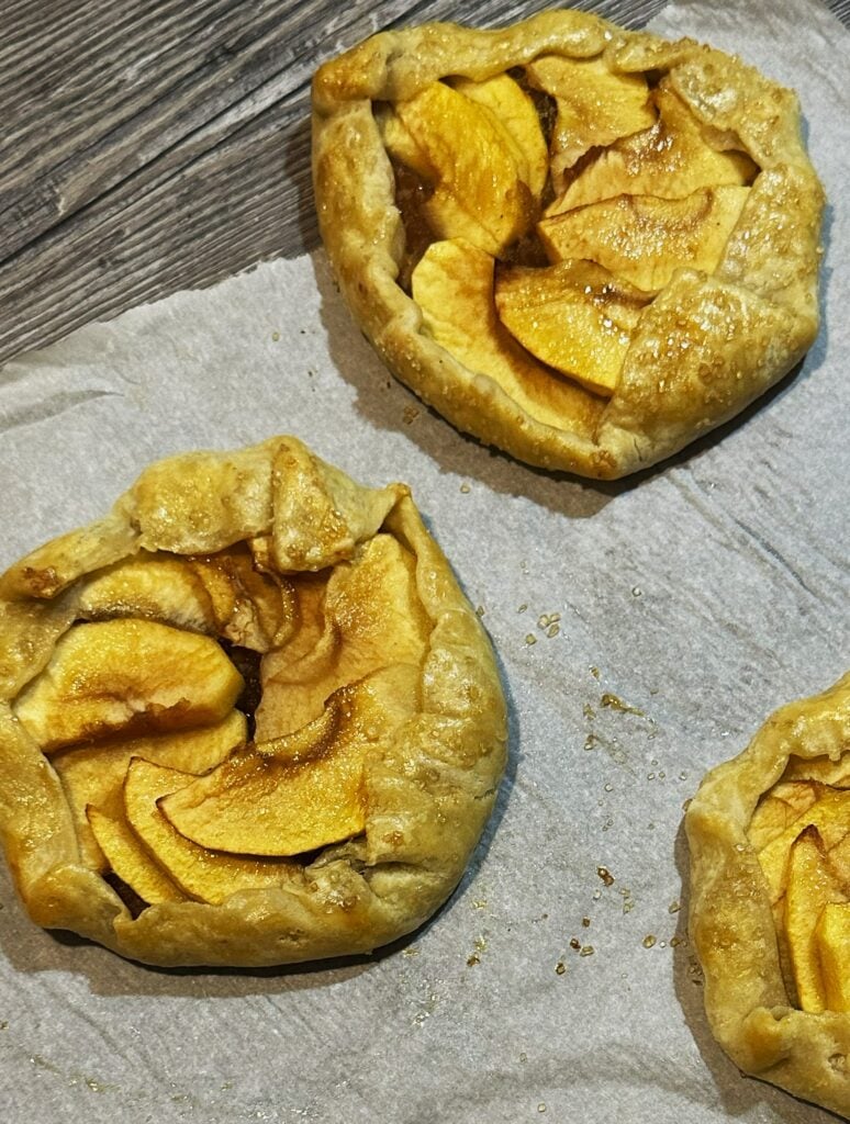 Two apple galettes on parchment paper.