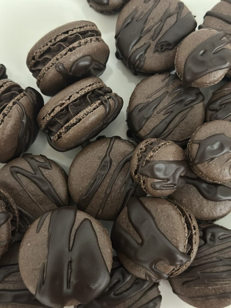 Dark chocolate espresso macarons arranged on a surface.