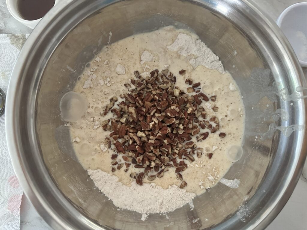 Wet and dry ingredients added together in a mixing bowl.