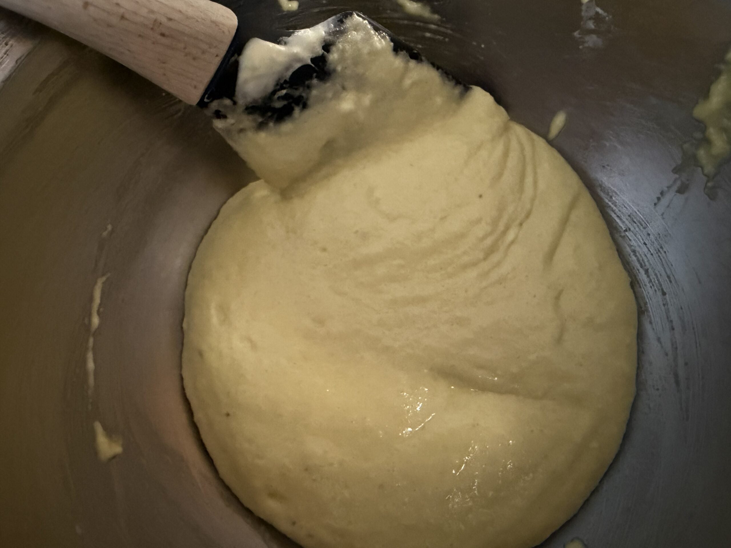 Mixing the macaronage to make a cohesive batter. Yellow food coloring added.