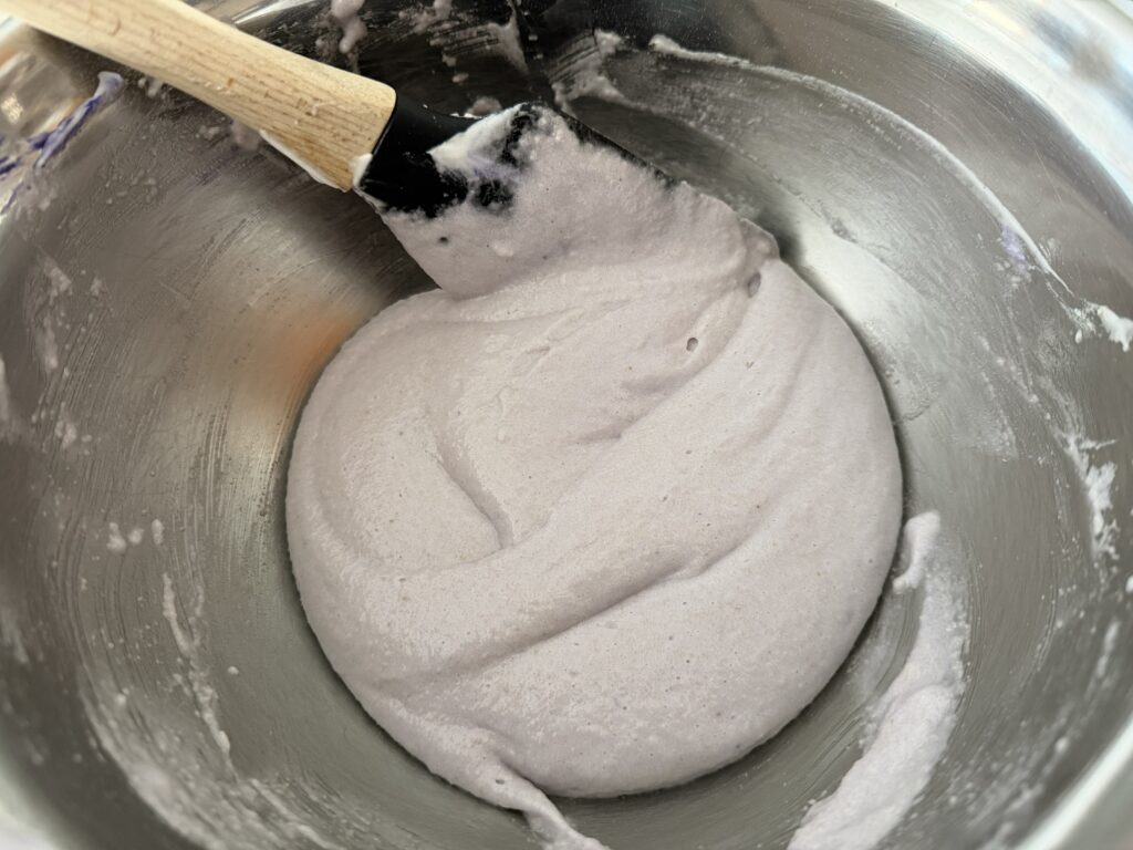 Demonstrating technique to properly mix the macaronage.