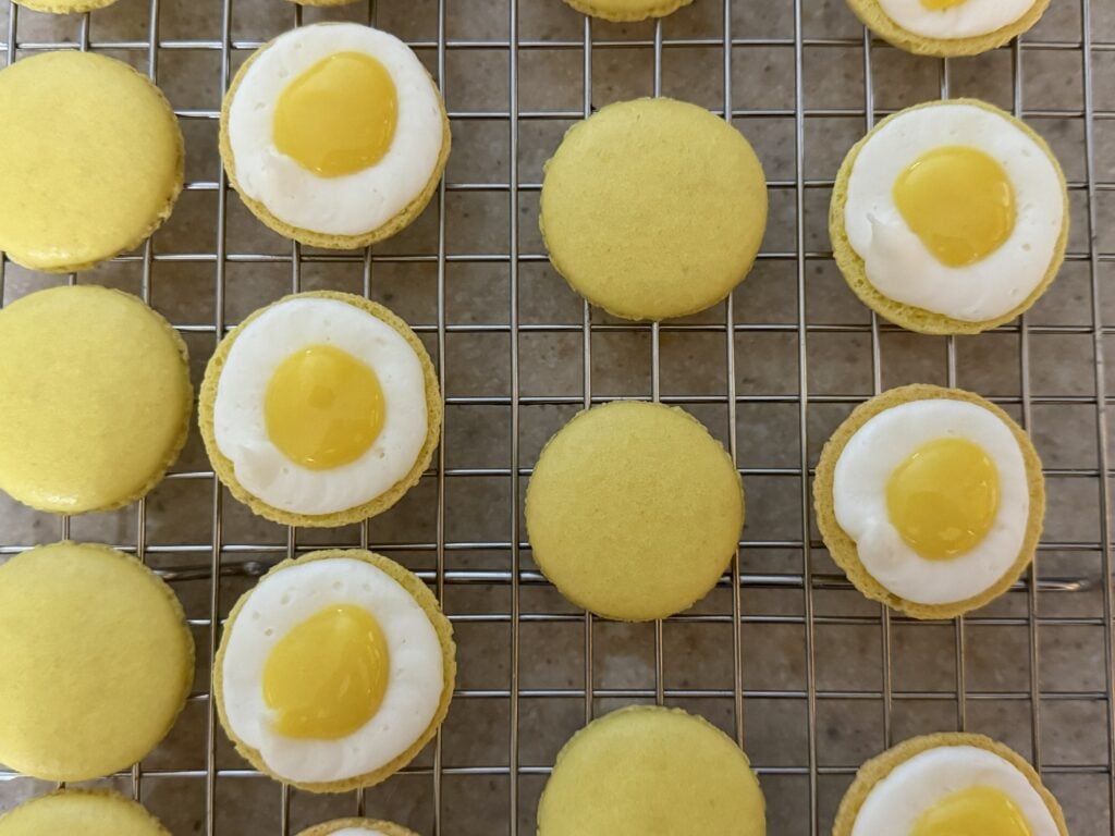 Lemon macarons showing the buttercream ring surrounding lemon curd on the shells.