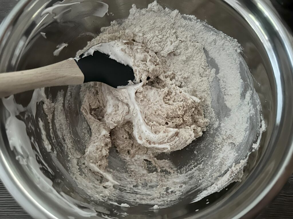 Mixing the meringue and powdered sugar/almond flour mixture.