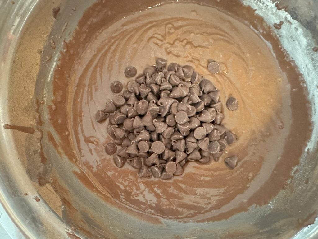 Adding chocolate chips into the batter.