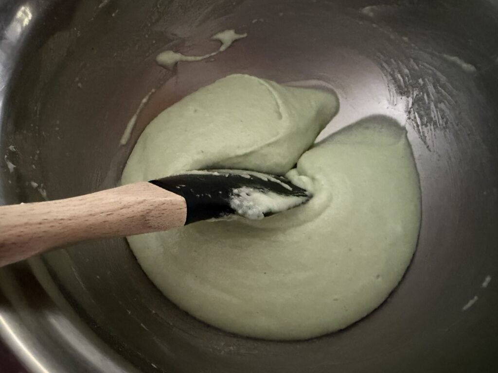 Dragging the spatula through the macaronage to help make a cohesive batter.