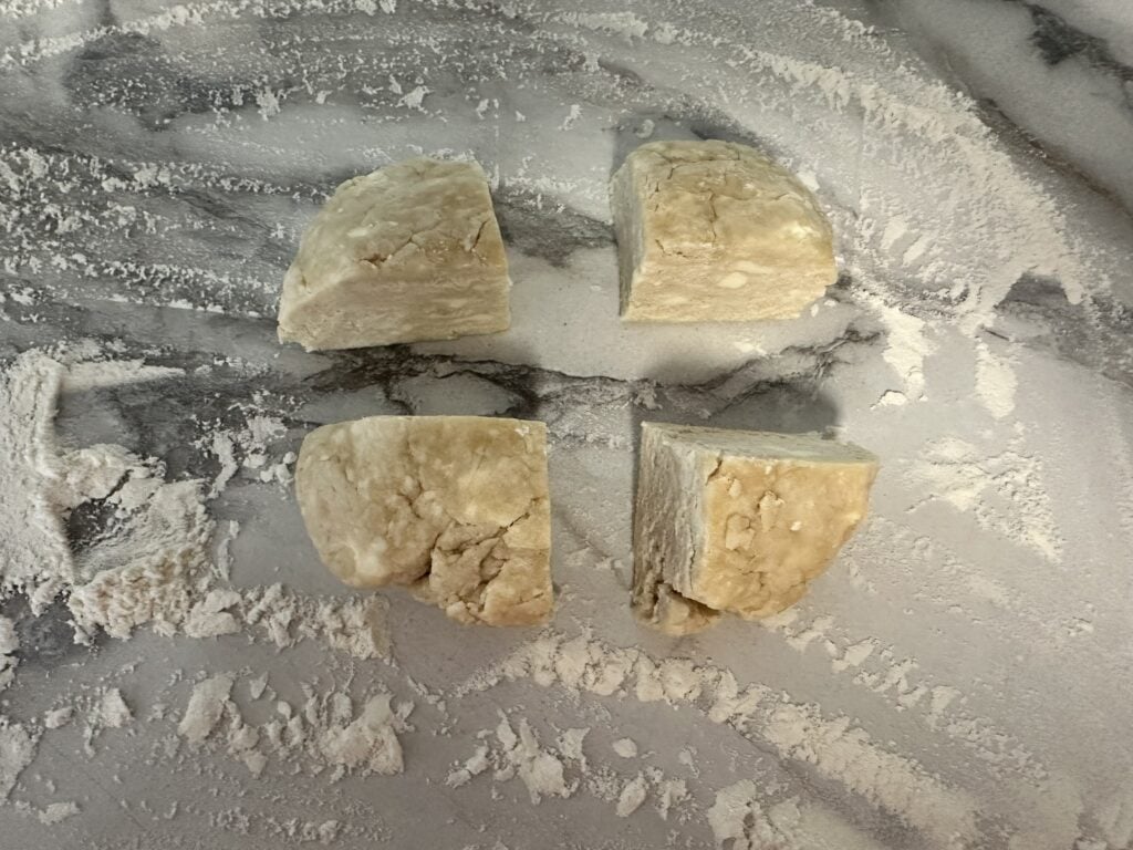 Pie dough ball cut into four pieces.