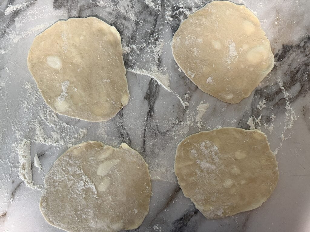 Four pieces of pie dough rolled out into 5-6 inch diameter circles.