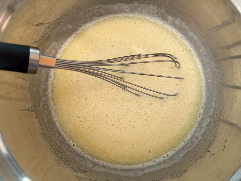 Milk and butter whisked into the sugar and eggs.