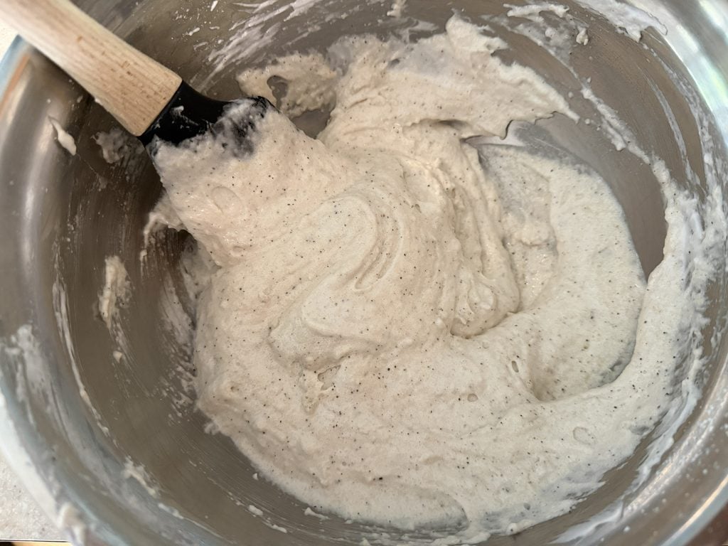 Demonstrating the technique of scraping along the side of the bowl under the mixture to make macaronage.