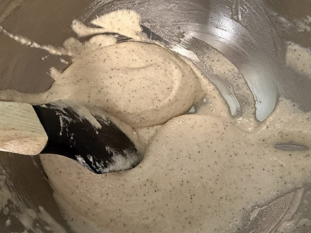 Dragging the spatula through the macaronage to help deflate the batter.