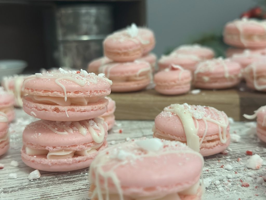 White chocolate peppermint macarons stacked on top of each other.