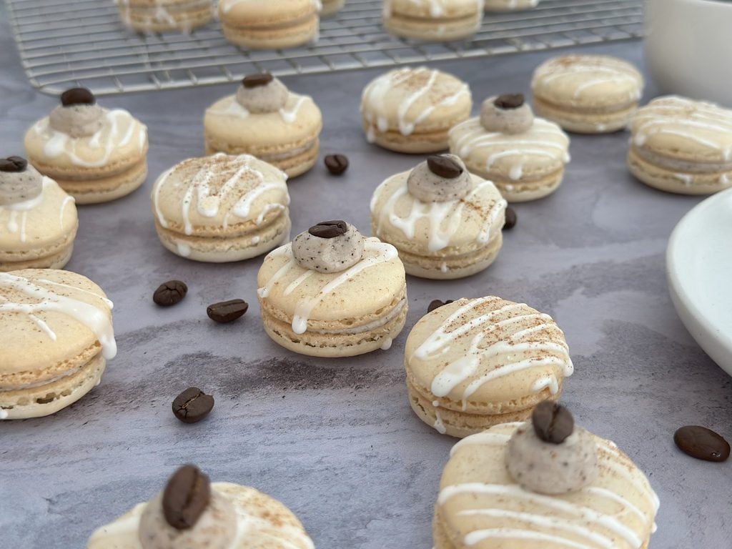 White mocha macarons arranged on a surface.